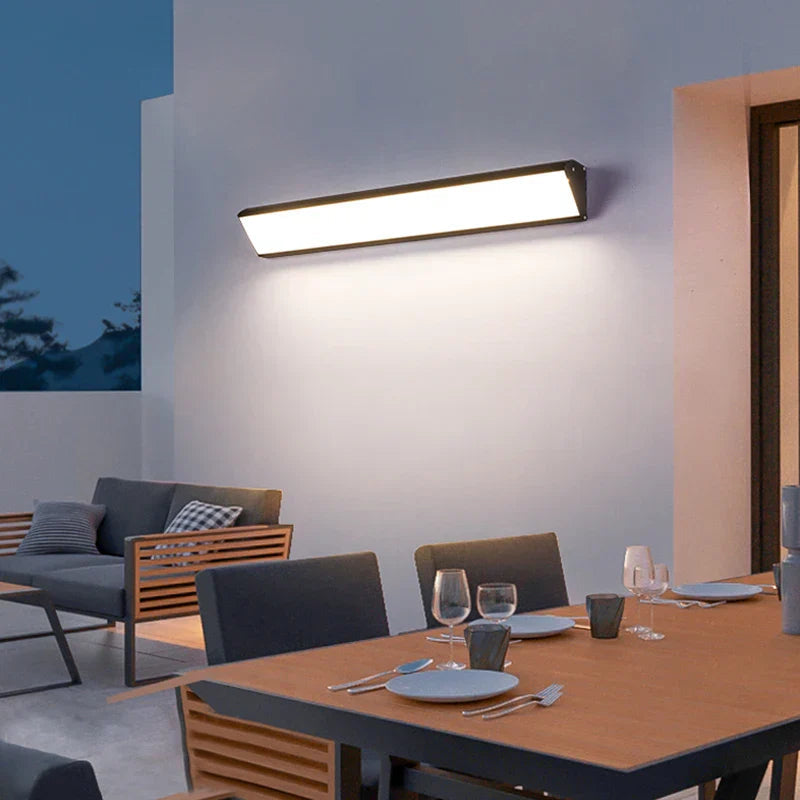 Linear LED outdoor wall light illuminating a house facade at night