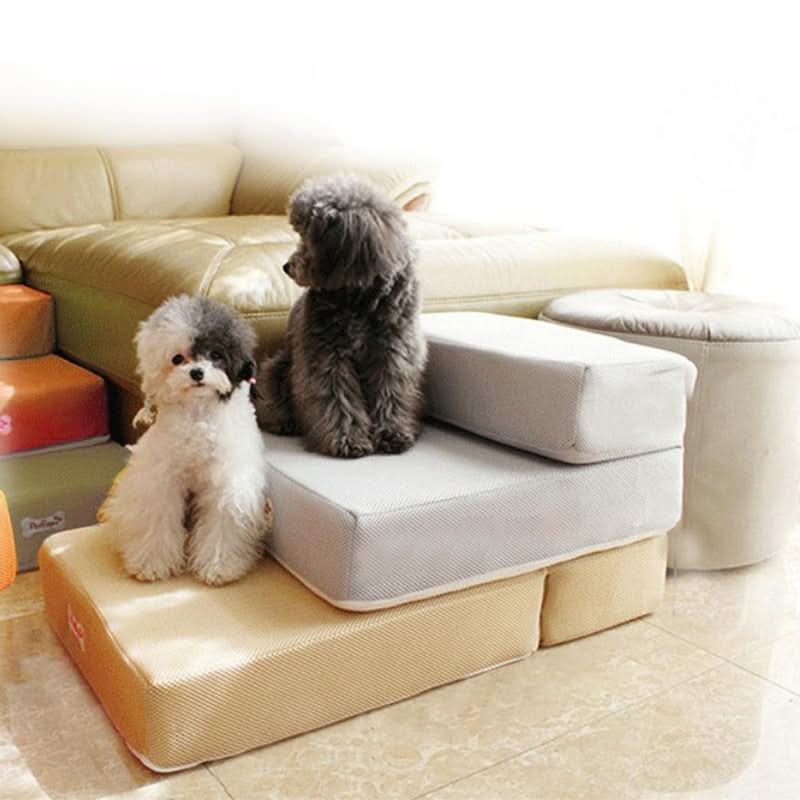 Two-step dog stairs with non-slip mesh cover next to a bed