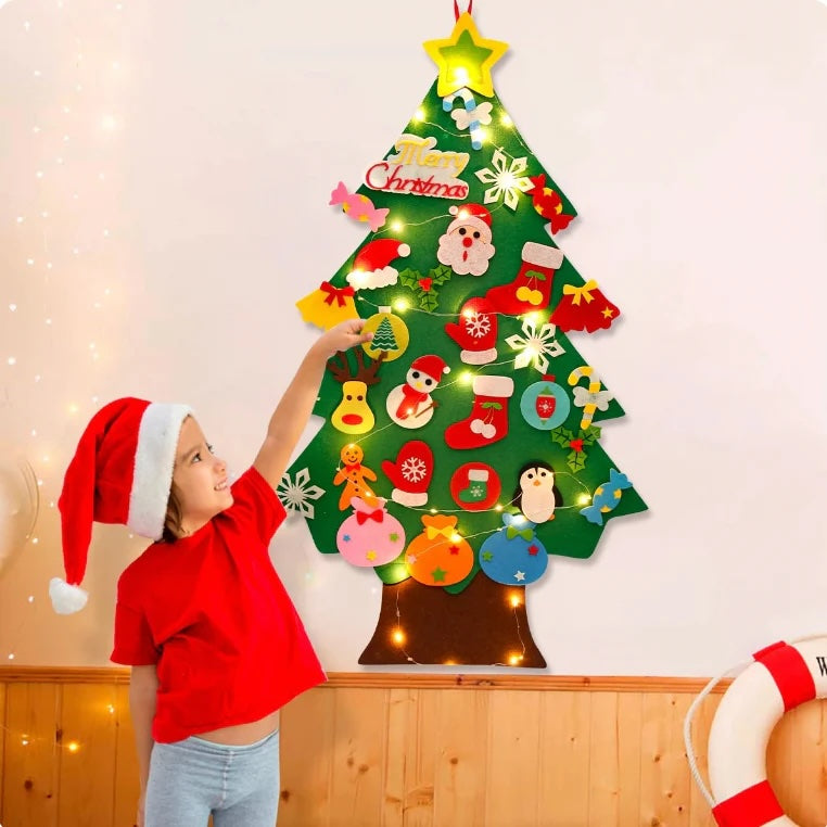Child decorating a felt Christmas tree on the wall with felt ornaments