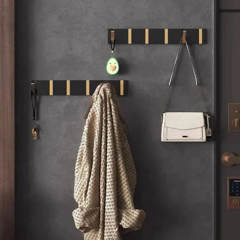 Foldable aluminum wall hook rail with coats hanging in a hallway