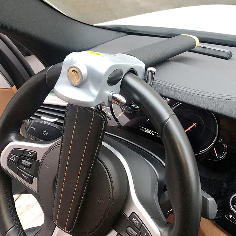 Hardened steel steering wheel lock fitted across a car steering wheel
