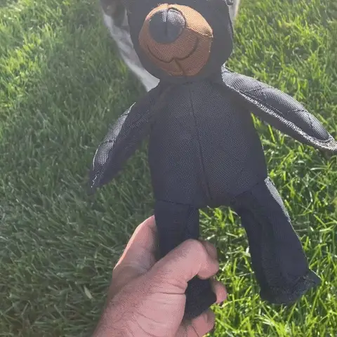 Plush bear dog toy standing on a wooden deck
