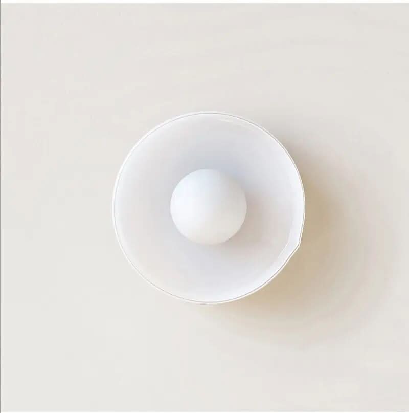 Nordic ceiling light with transparent glass shade glowing above a dining table