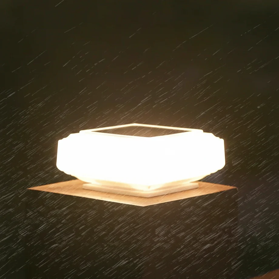 Solar post cap light glowing warm white on a wooden fence post at dusk