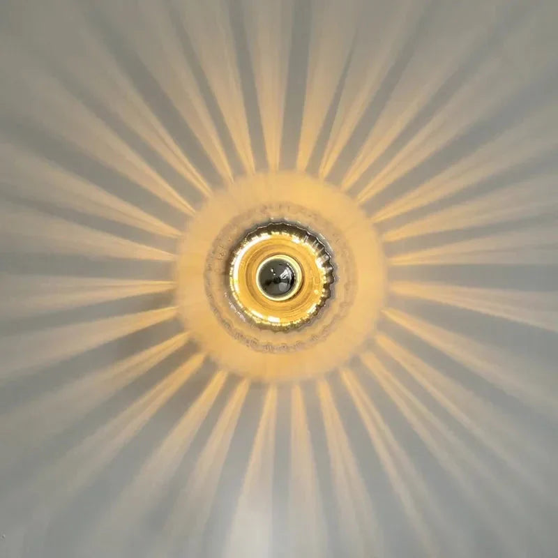 Modern glass globe wall lamp mounted beside a bed, casting a soft warm glow in a cozy bedroom.