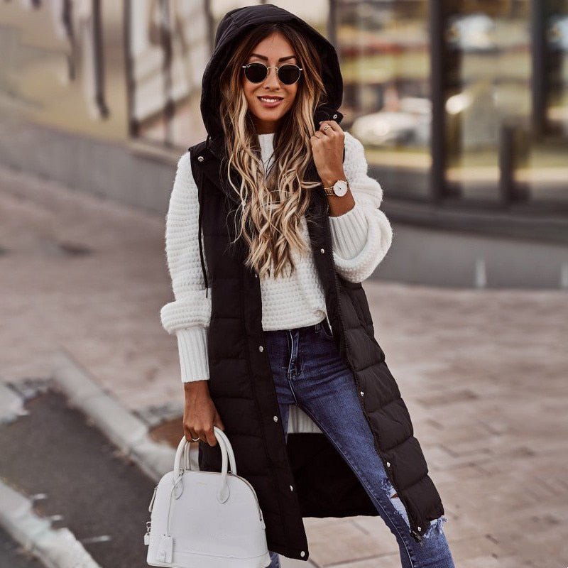 Woman wearing a long quilted puffer vest with hood over a sweater