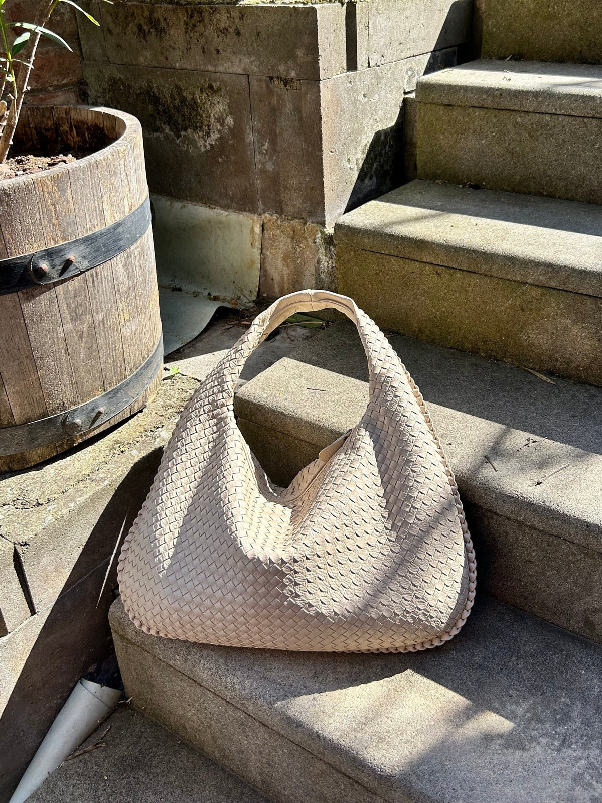Woman carrying a black tote bag over her shoulder on a city street