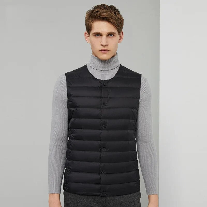 Layering demonstration showing the men's down vest worn comfortably under a heavy winter jacket.