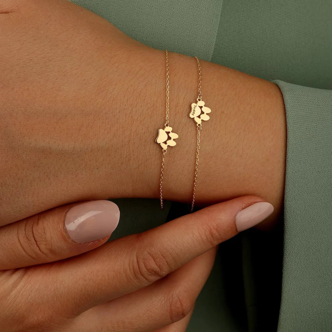 A woman wearing the custom stainless steel paw print charm bracelet on her wrist while petting her dog.