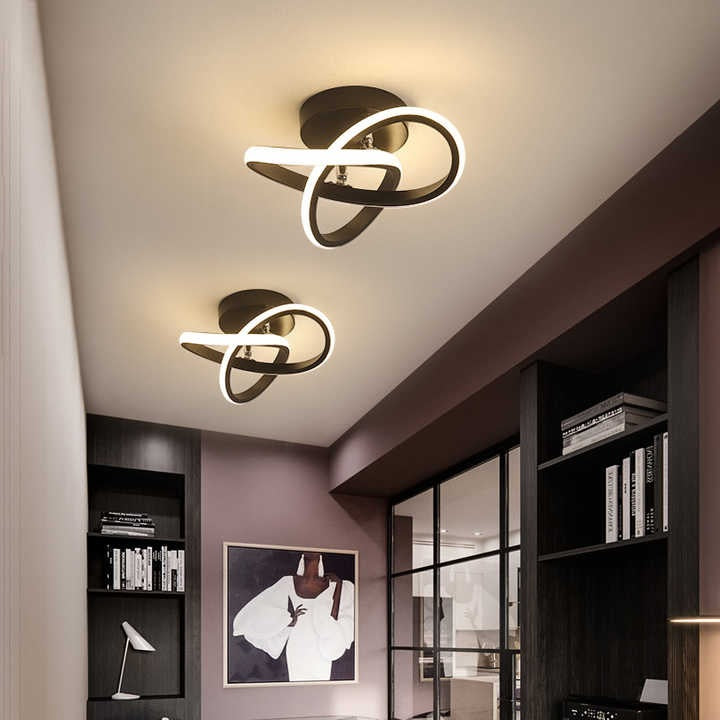 Twisted ribbon LED ceiling light glowing along its inner edge