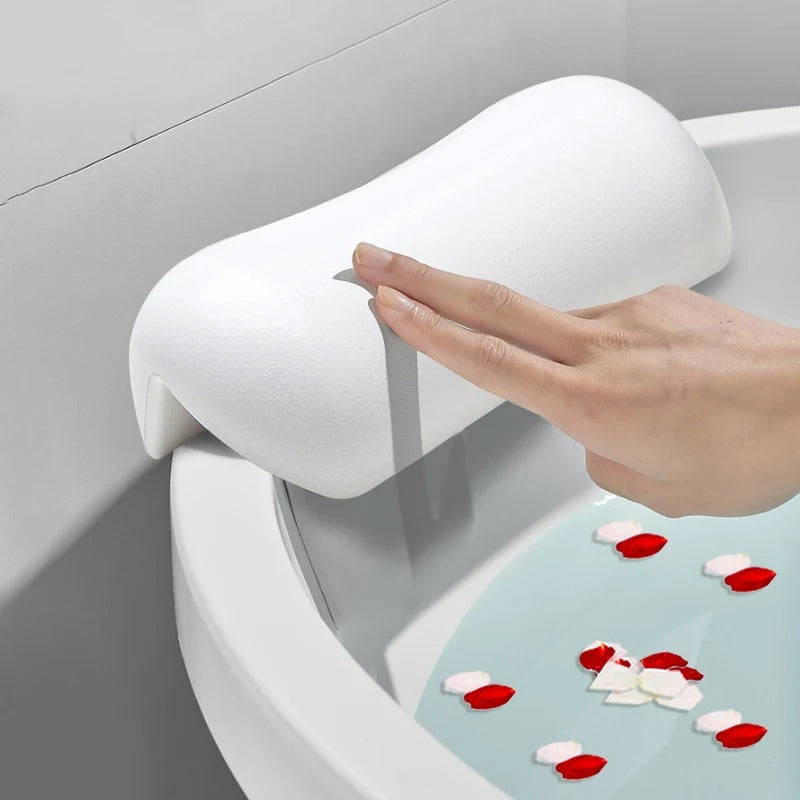 Ergonomic bath pillow attached to a bathtub with suction cups
