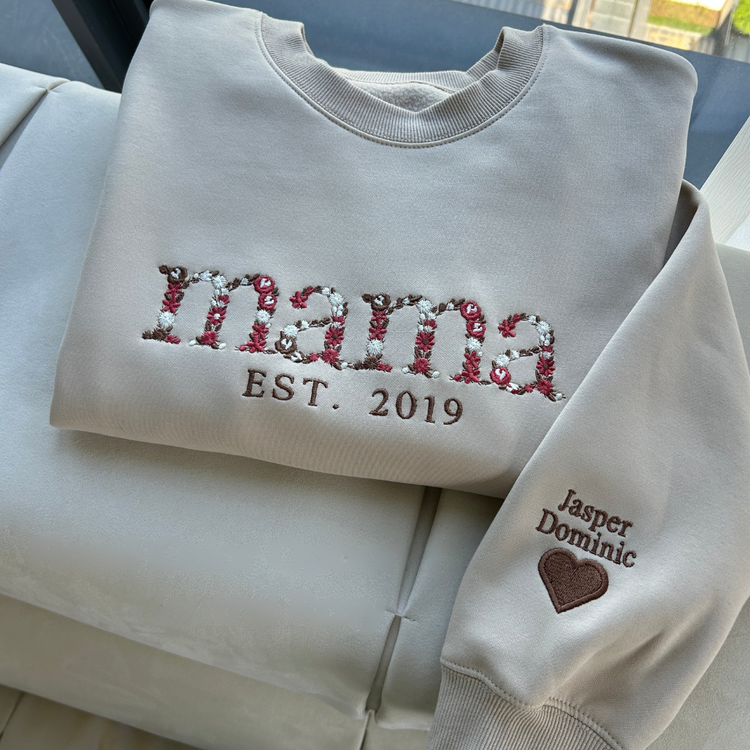 Front view of a custom embroidered mom sweatshirt featuring floral letters spelling Mama with established year.