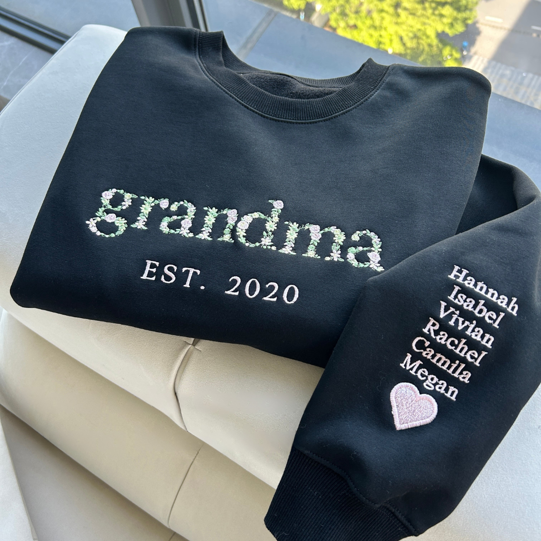 A woman wearing the personalized floral embroidered crewneck sweatshirt while relaxing outdoors.