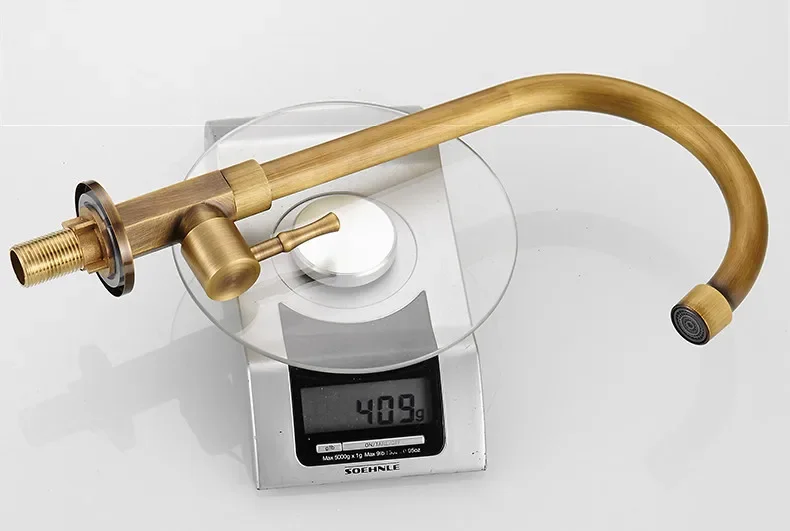Close-up of the antique brass faucet handle and gooseneck spout