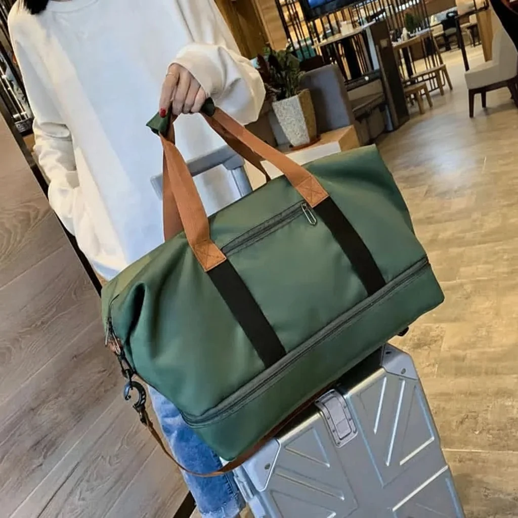 Gym bag mounted on a rolling suitcase with the trolley sleeve