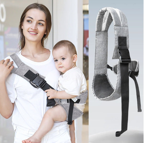 Parent wearing a hip seat baby carrier with a child seated on the hip
