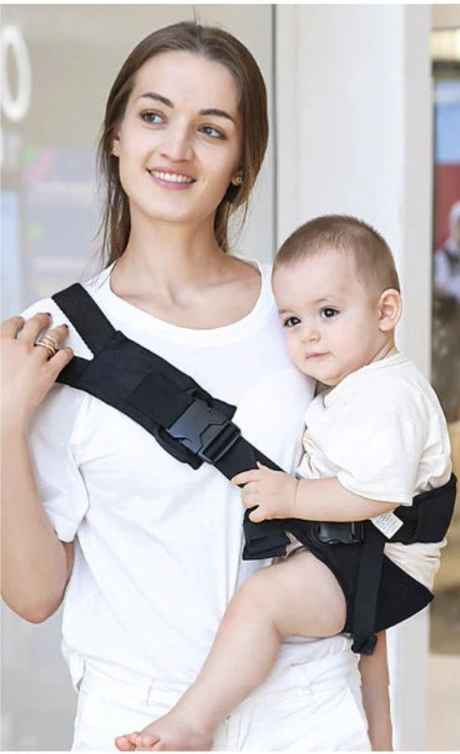 Woman wearing the black hip seat baby carrier