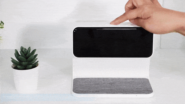 White LCD alarm clock with lamp and wireless charging pad on a nightstand