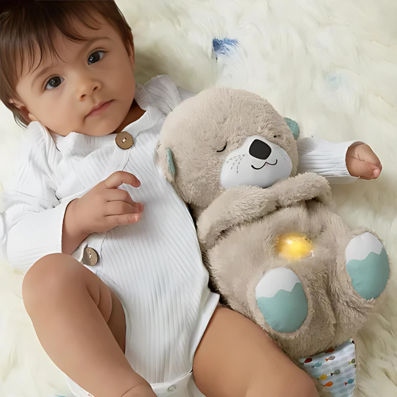 A toddler sleeping peacefully in bed next to the breathing plush toy with its warm nightlight glowing.