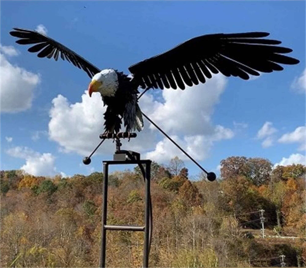 Metal owl wind spinner on a stake on a patio