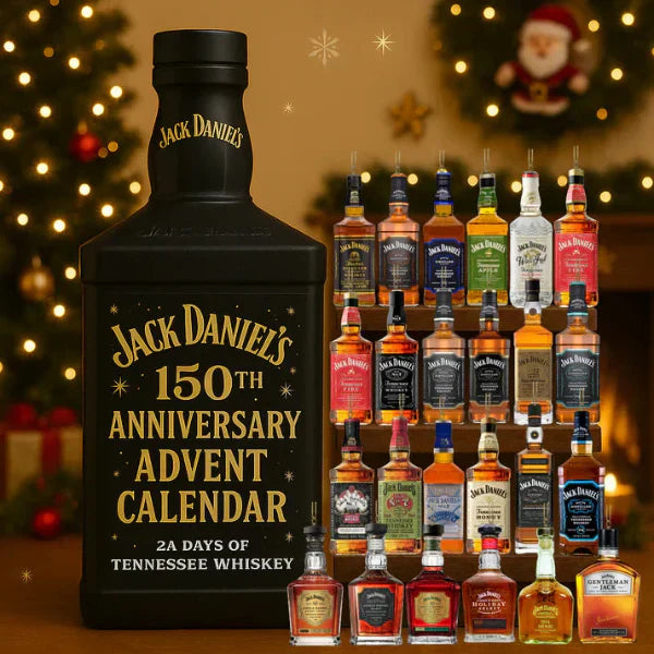 Close-up of a miniature whisky bottle ornament hanging on a green Christmas tree branch.