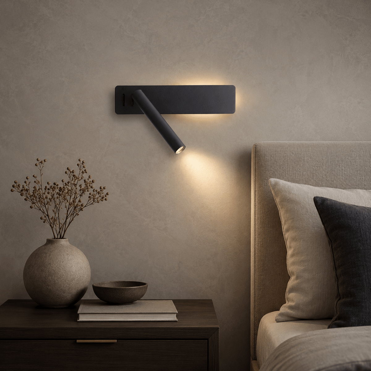 Rotating LED wall light aimed at a book beside the bed