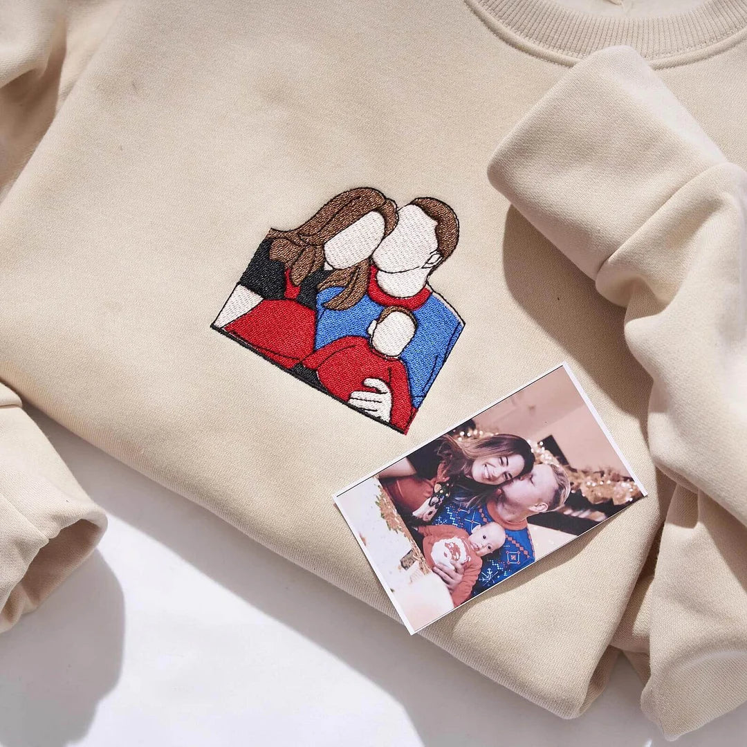 A grey custom photo embroidered sweatshirt featuring a minimalist stitched outline portrait of a couple.