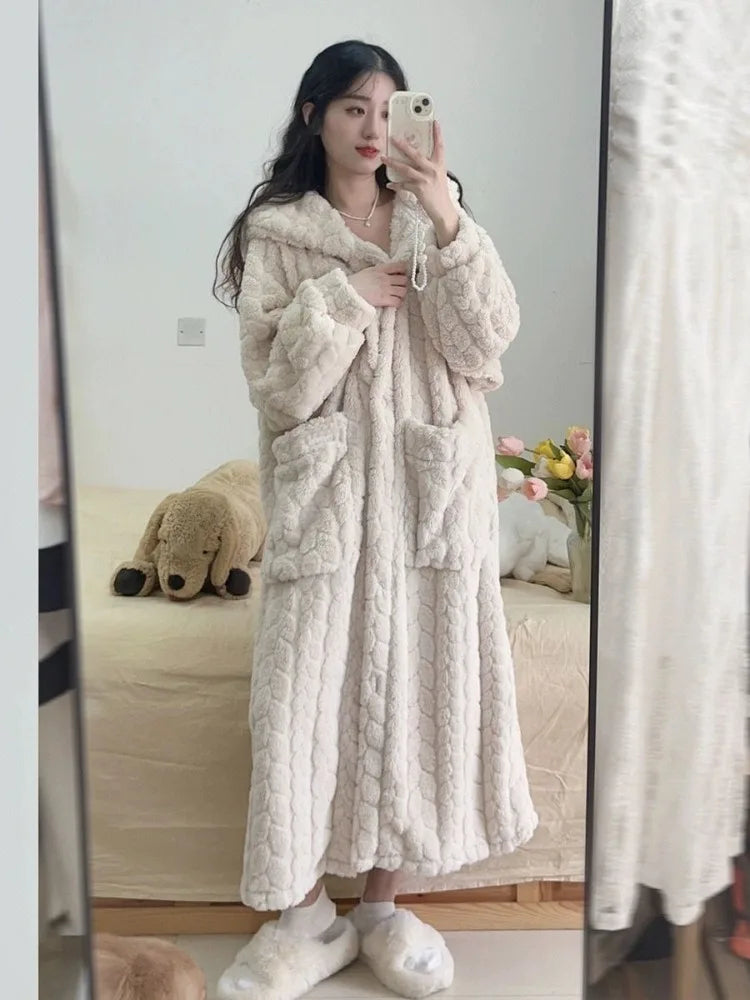 Woman wearing a long hooded bathrobe at home