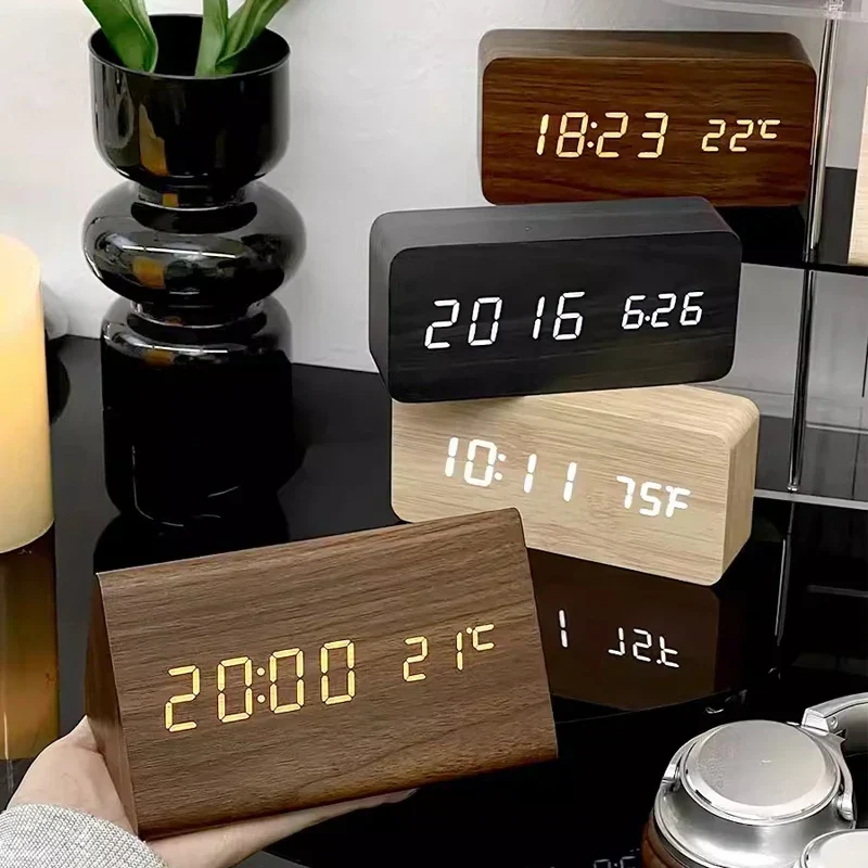 Wooden digital alarm clock showing time and temperature on a nightstand